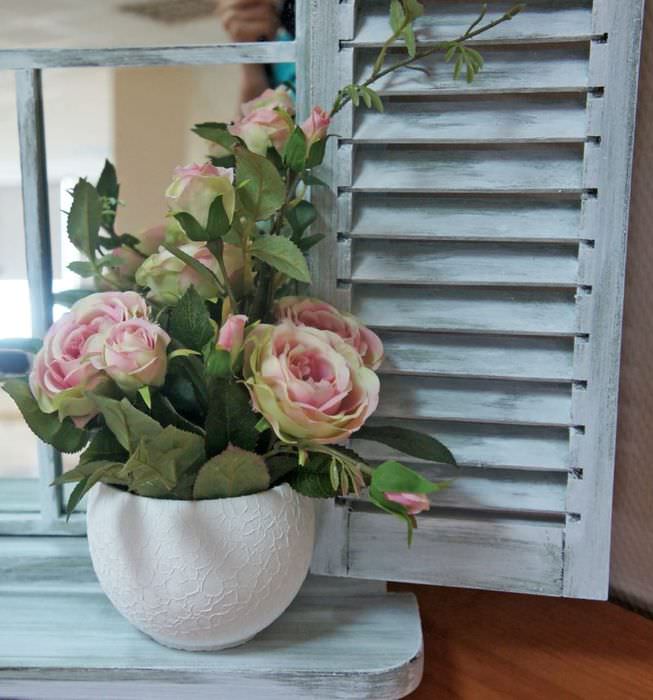 Горшок с цветущими розами на деревянном подоконнике
